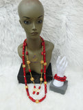 Red beaded necklace with gold accents on a mannequin bust, accompanied by a white hand wearing a red bracelet on a white textured background.